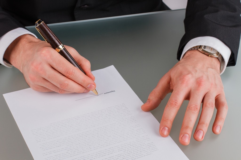 businessman-hands-sign-contract-on-desk-2021-09-02-15-12-41-utc.jpg